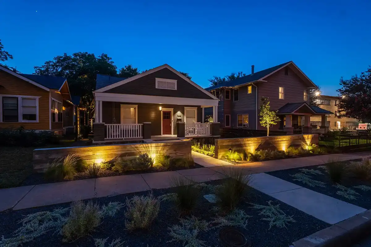 residetnail home at night featuring landscape lights